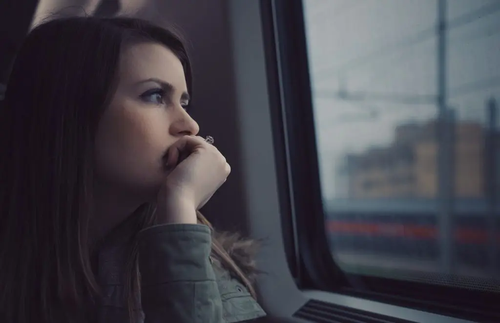 depression Photo of woman staring out train window considering the Fast phobia release and worrying